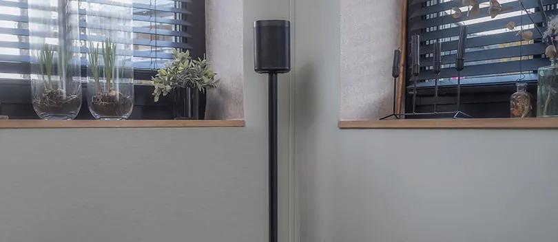 Multiroom speaker op speakerstandaard in woonkamer.