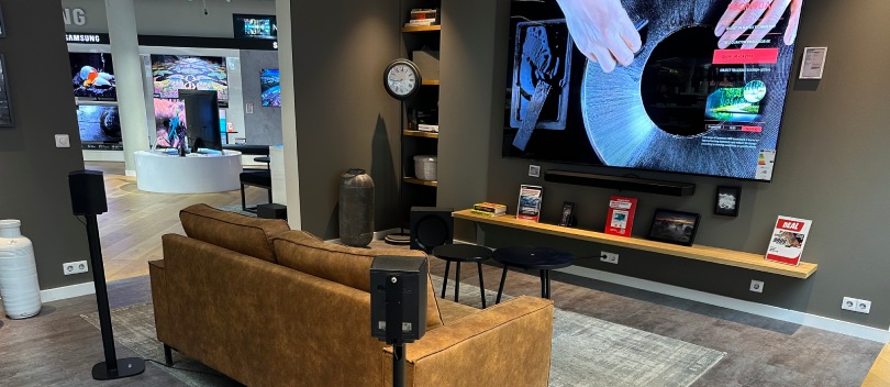 Samsung speaker standaard eenvoudig online bestellen Samsung speakers gemonteerd op een Samsung standaard, staand achter een bank