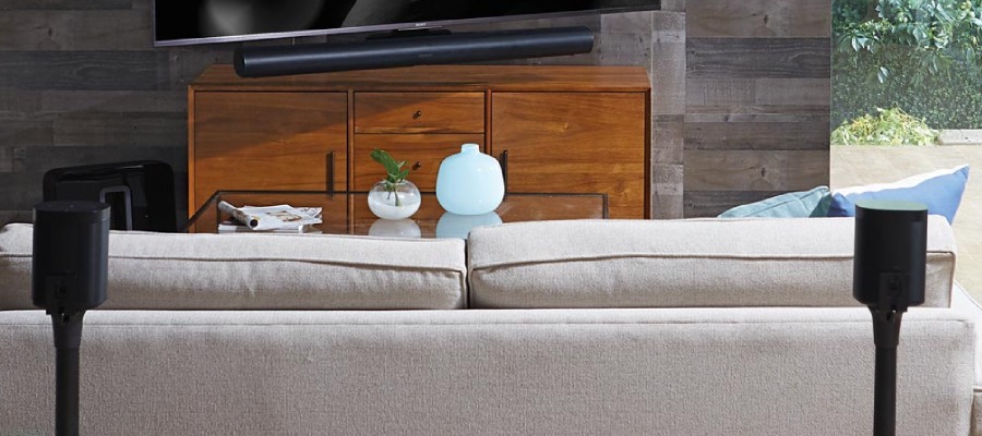 zithoek in een woonkamer met een televisie op een tv meubel met ernaast twee zwarte speakerstandaarden van Vebos